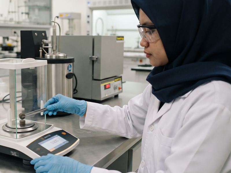 Ilustrasi teknisi laboratorium menimbang sampel biomassa